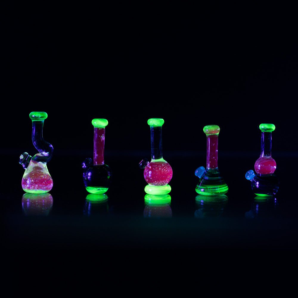 Five piece set of trippy neon bongs made for lego figurines. Each bong piece has a UV green base a5-Piece Trippy Neon Block Glass Bong Set Empire Smokesnd mouth piece, with a UV pink stem.