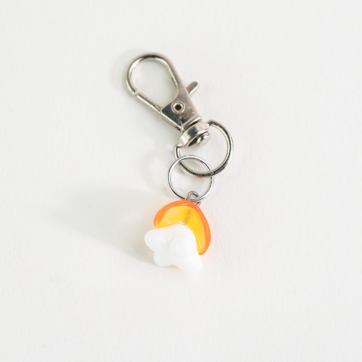 Close-up of the Mmmelty sunrise glass charm with colorful detail