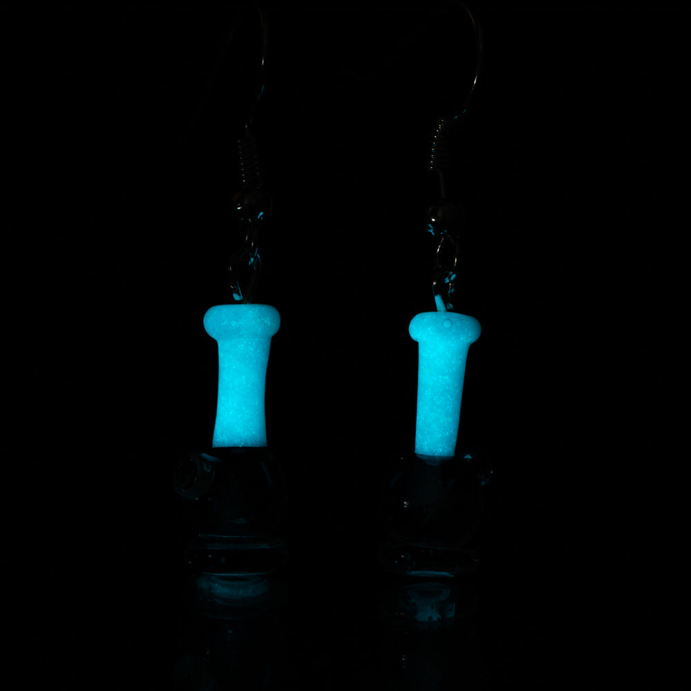 A pair of opal bong earrings under UV light. The Base of the earring is glowing blue and the stem is glow in the dark. ear rings