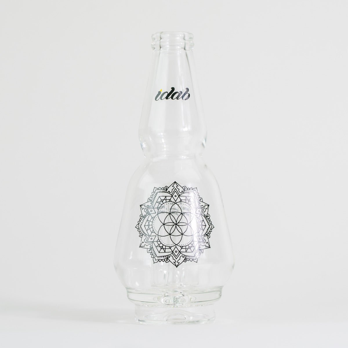 Clear glass bottle with floral design and text on white background