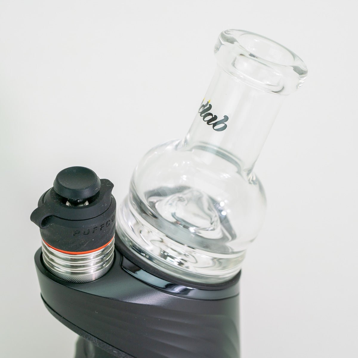 Glass water bottle with black cap and silver base on a white background