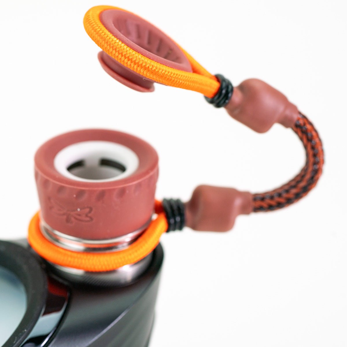 Closeup of brown and orange accessory on Puffco device