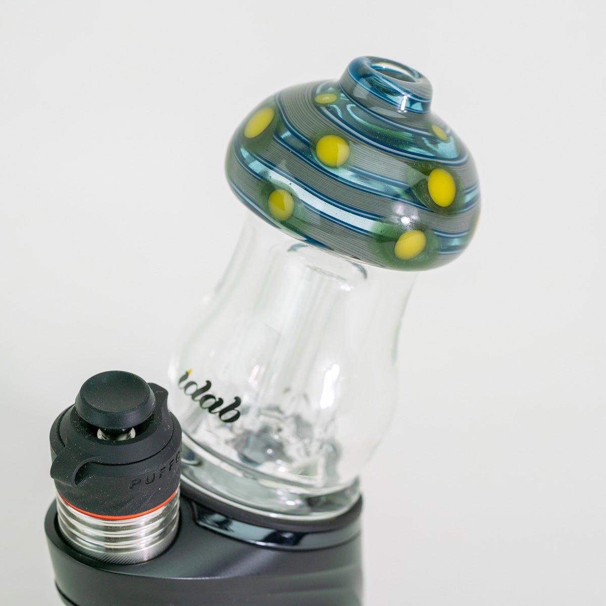 Glass smoking device with colorful top and black base on a white background