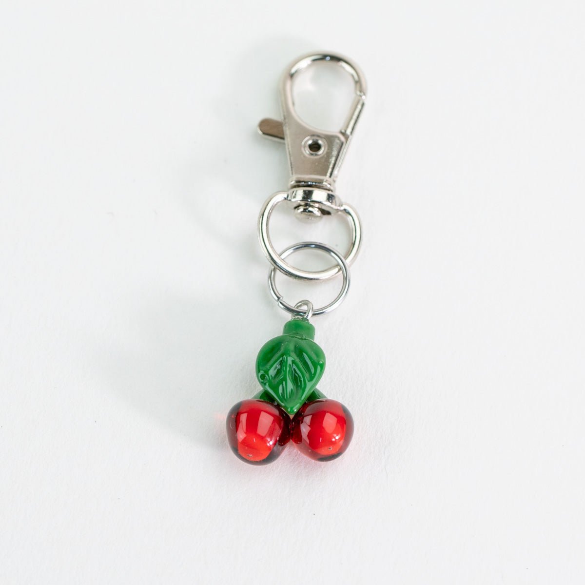 Glass Puffco keychain with cherry design on a white background