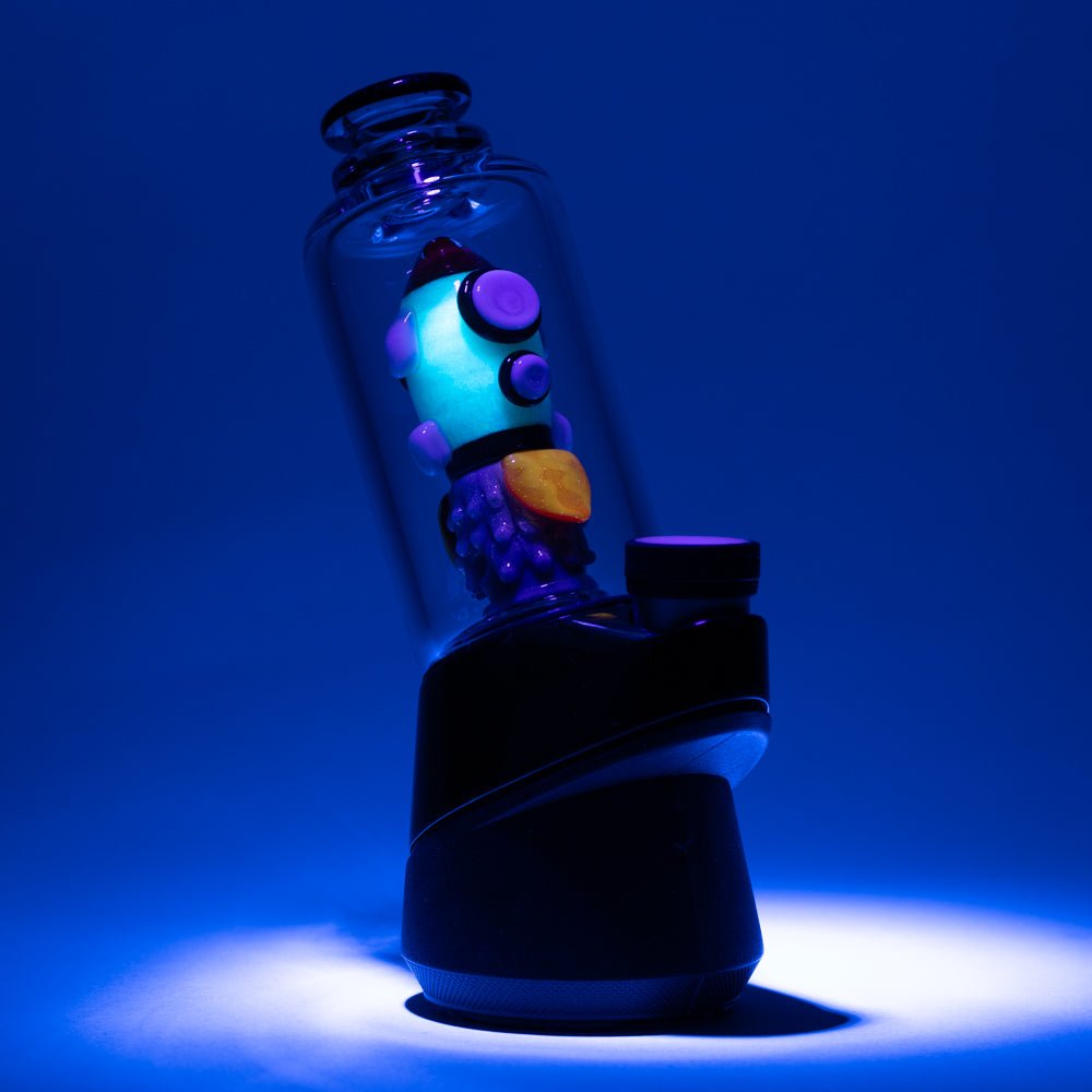 Empire Glassworks rocket themed Puffco glass attachment in clear chamber with UV light applied