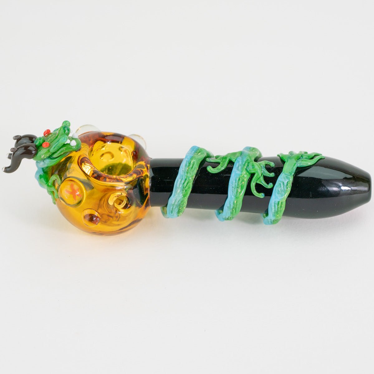A glass small spoon pipe sideways with dragon design