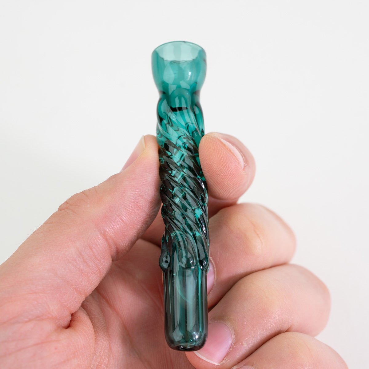 Teal borosilicate glass pinch hitter chillum held in hand