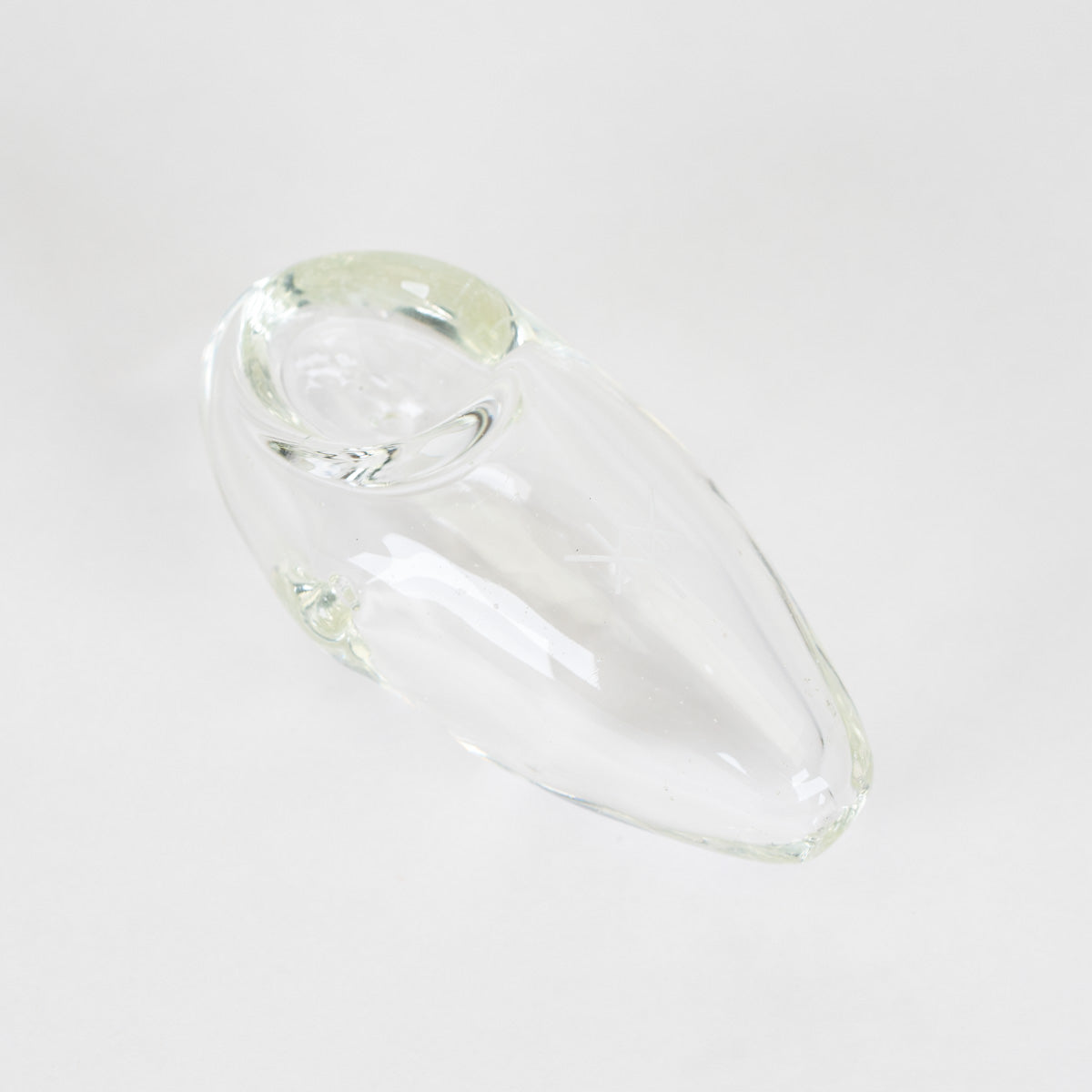 A clear glass smoking pipe with a rounded, teardrop-shaped body and a small circular bowl at one end, shown on a plain light gray background.