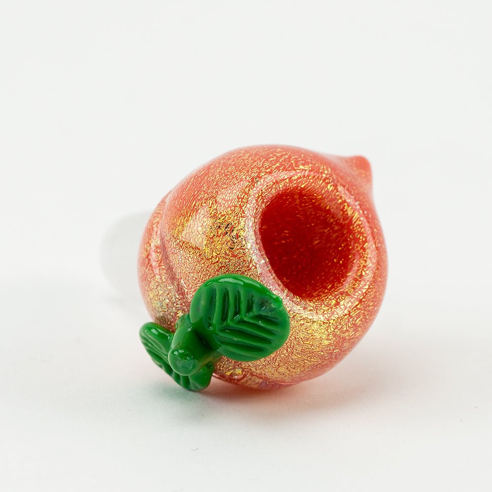Peach glass bowl piece with warm fruit-inspired color and sculpted leaf accents