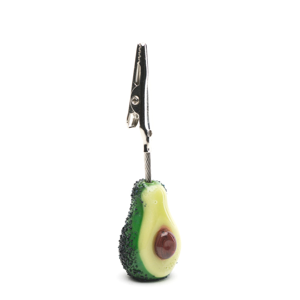 An avocado designed roach clip with metal teeth to hold joints.