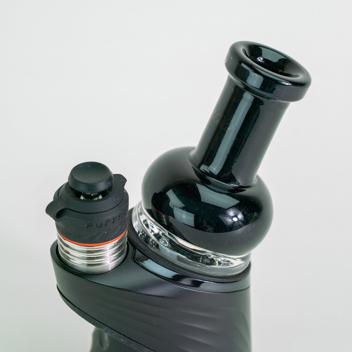 Black glass attachment on top of Puffco device with white background
