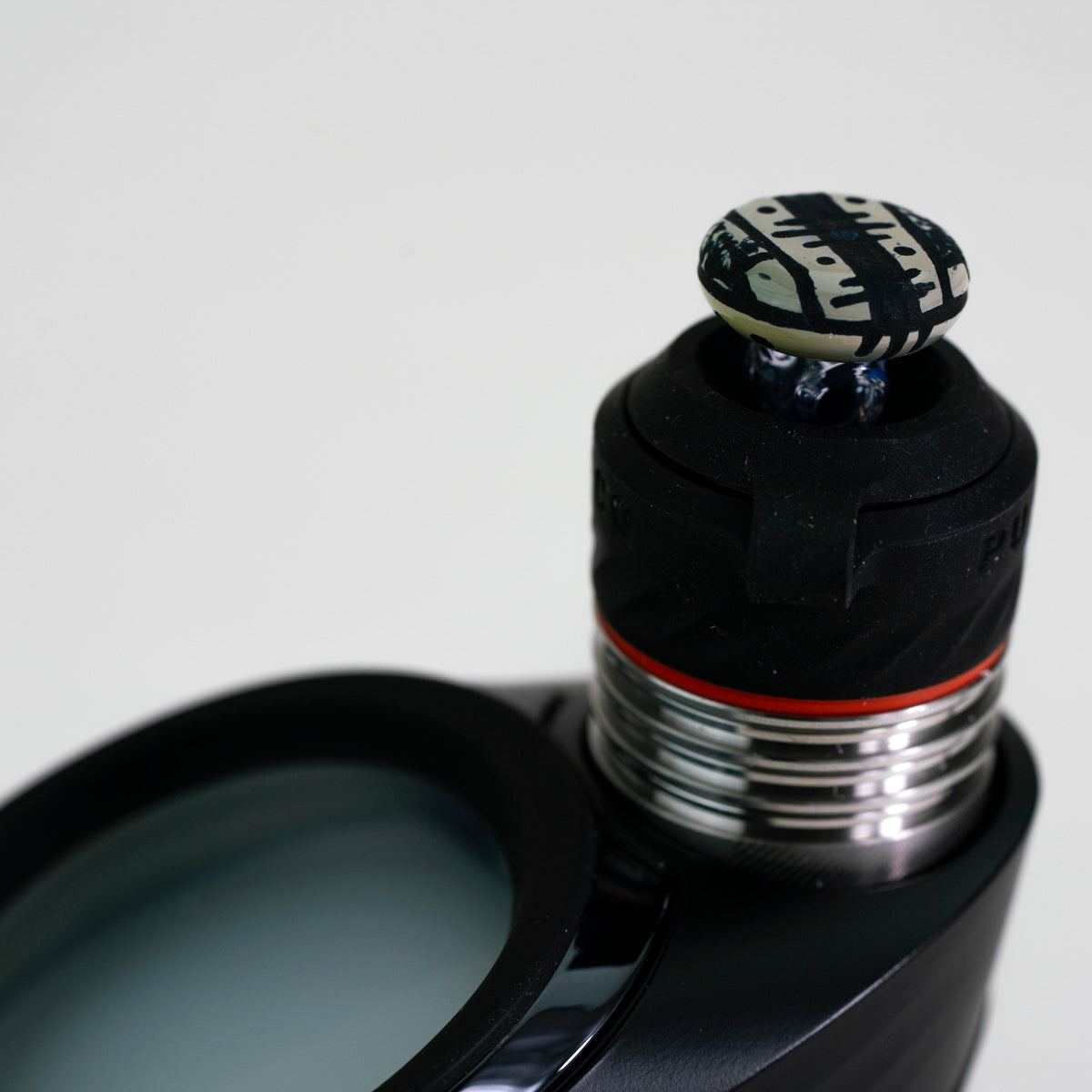 closeup of glass engraved joystick with puffco device