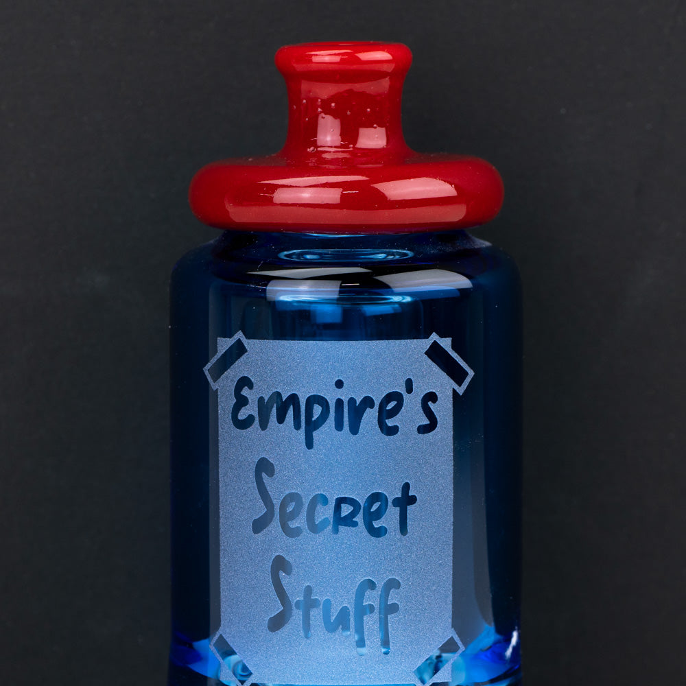 Blue PuffCo Glass bottle with the words "Empire's Secret Stuff" written on it. This puffco glass accessory is shaped for the Puffco Peak and PuffCo Peak Pro. Empire Smokes