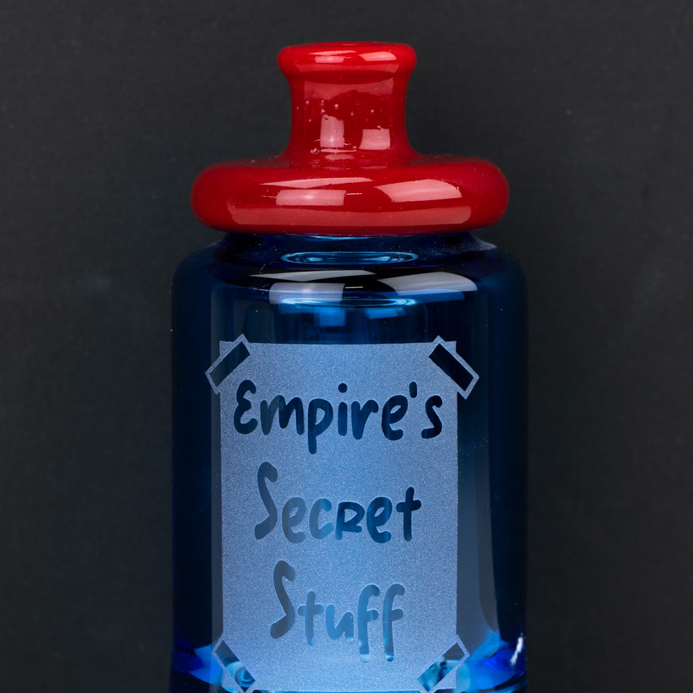 Blue PuffCo Glass bottle with the words "Empire's Secret Stuff" written on it. This puffco glass accessory is shaped for the Puffco Peak and PuffCo Peak Pro.