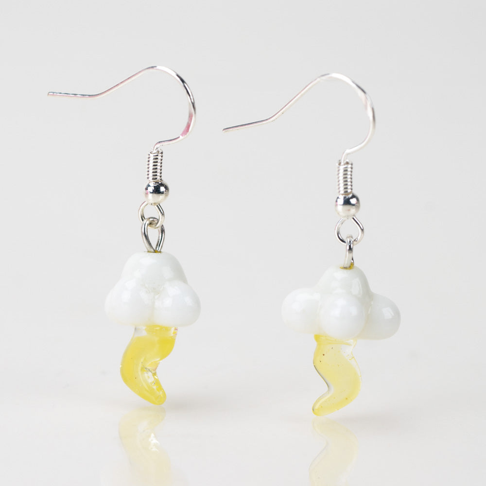 Two dangle style earrings shaped resembling a cloud and lightning bolt. The cloud and lightning bolt are made of glass. The cloud is a white color glass and the lightning bolt is a yellow color. Above the cloud is a sterling silver dangle backing. 