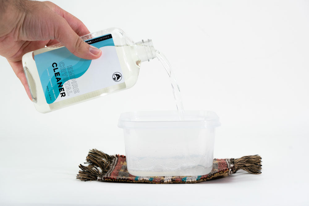 Hand pouring Empire alcohol liquid into container