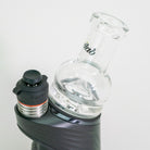 Glass water bottle with black cap and silver base on a white background