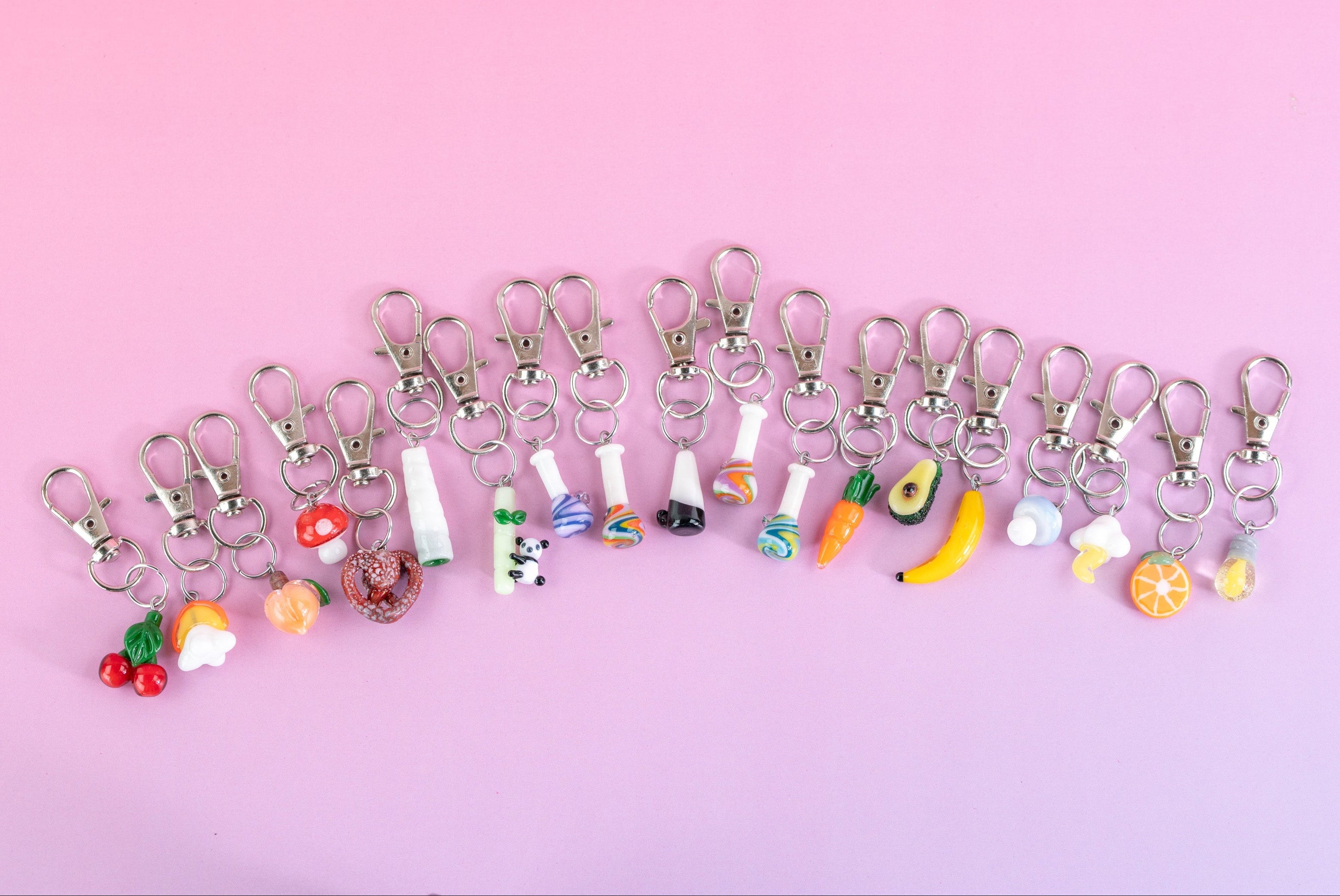 Collection of Puffco charms on pink background