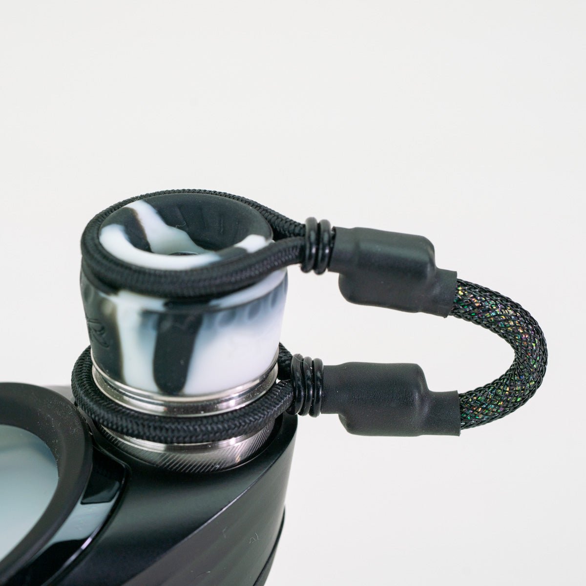 Closeup of black and white tether attachment on Puffco device