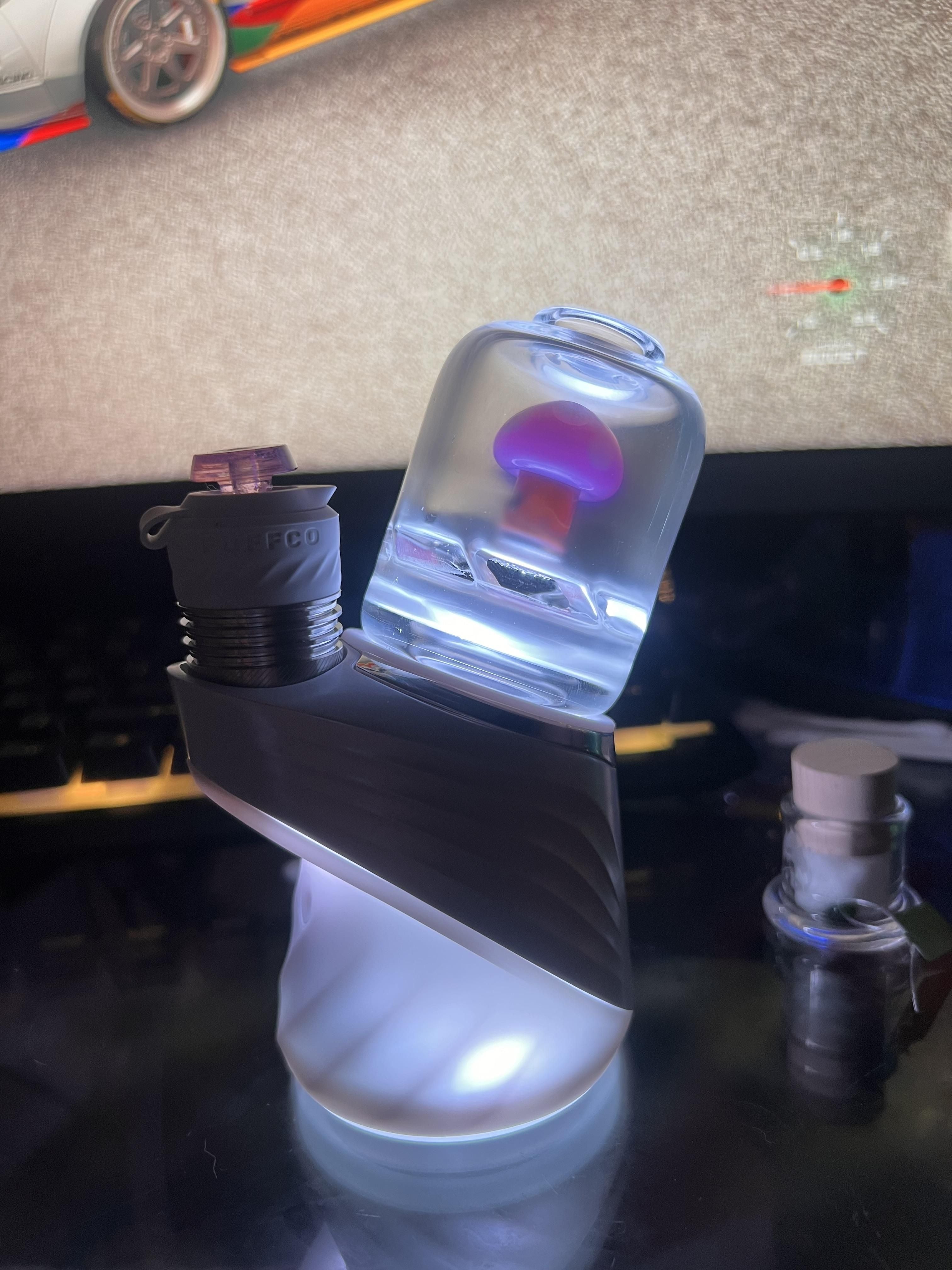 Puffco Peal Pro with lights on with a Purple Mushroom Glass Attachment