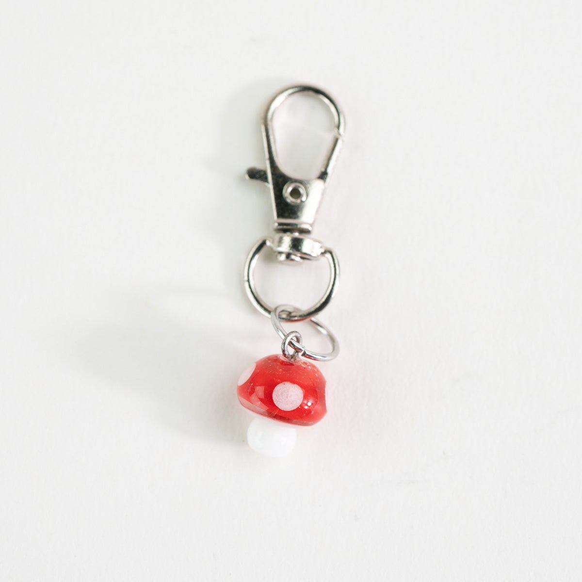 Keychain with a red mushroom charm on a white background