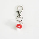 Keychain with a red mushroom charm on a white background