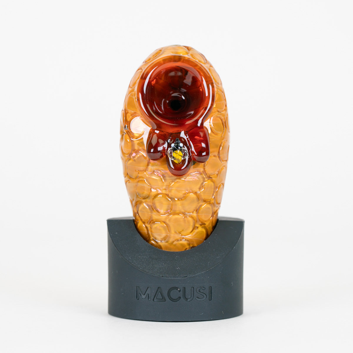 Beehive Macusi glass pipe with small bee figurine in honey on a white background
