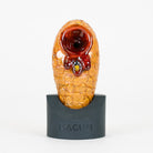 Beehive Macusi glass pipe with small bee figurine in honey on a white background