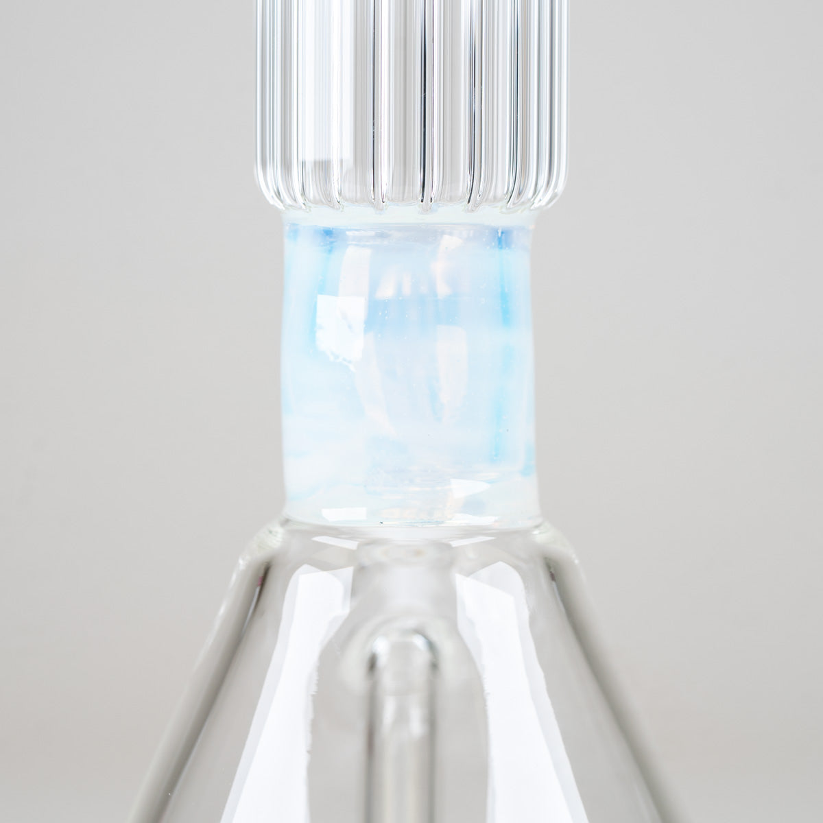 Close-up of the Celeste Signature Beaker's opalescent blue neck accent beneath the distinctive clear ribbed glass