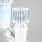 Angled close-up of the Celeste Signature Beaker's clear ribbed bowl with its opalescent blue neck accent in the background