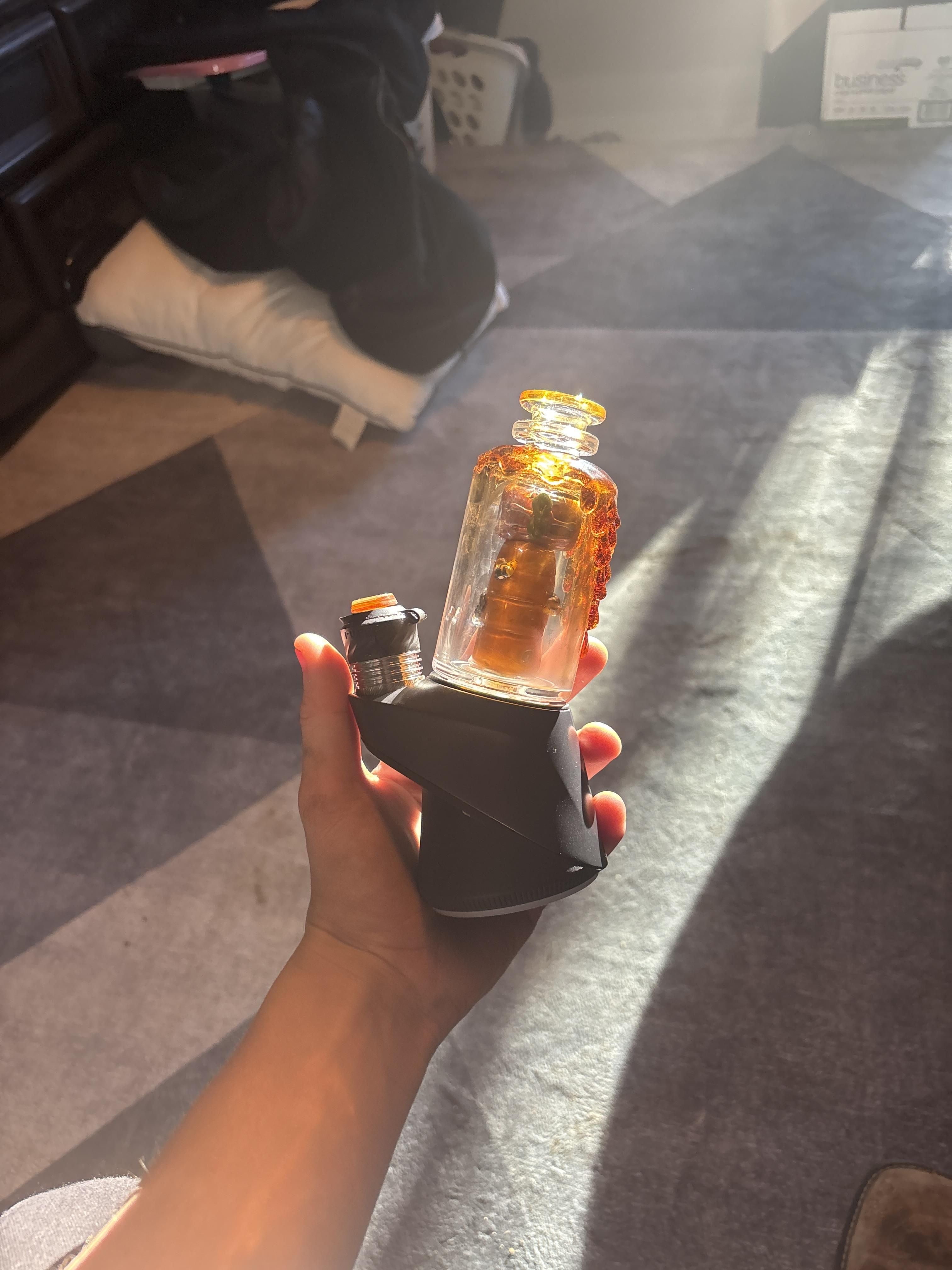 A customer holding the Save the Bees Puffco Peak Attachment on the Puffco Peak Pro