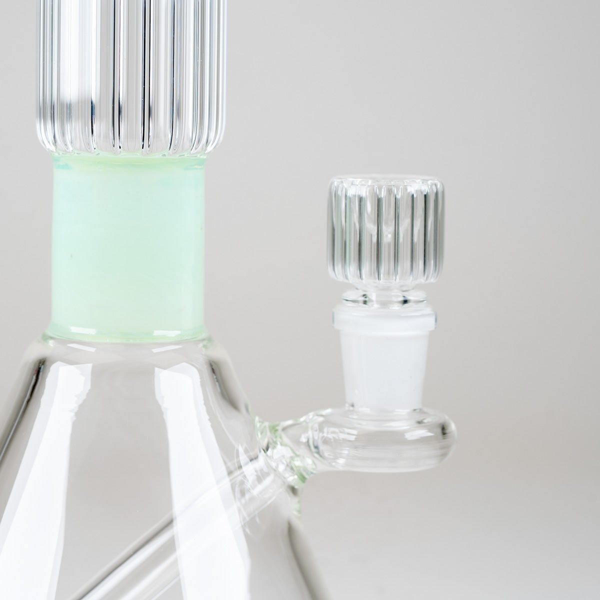 Detailed view of the Julep Signature Beaker's matching ribbed glass bowl, frosted joint, and mint-green neck section