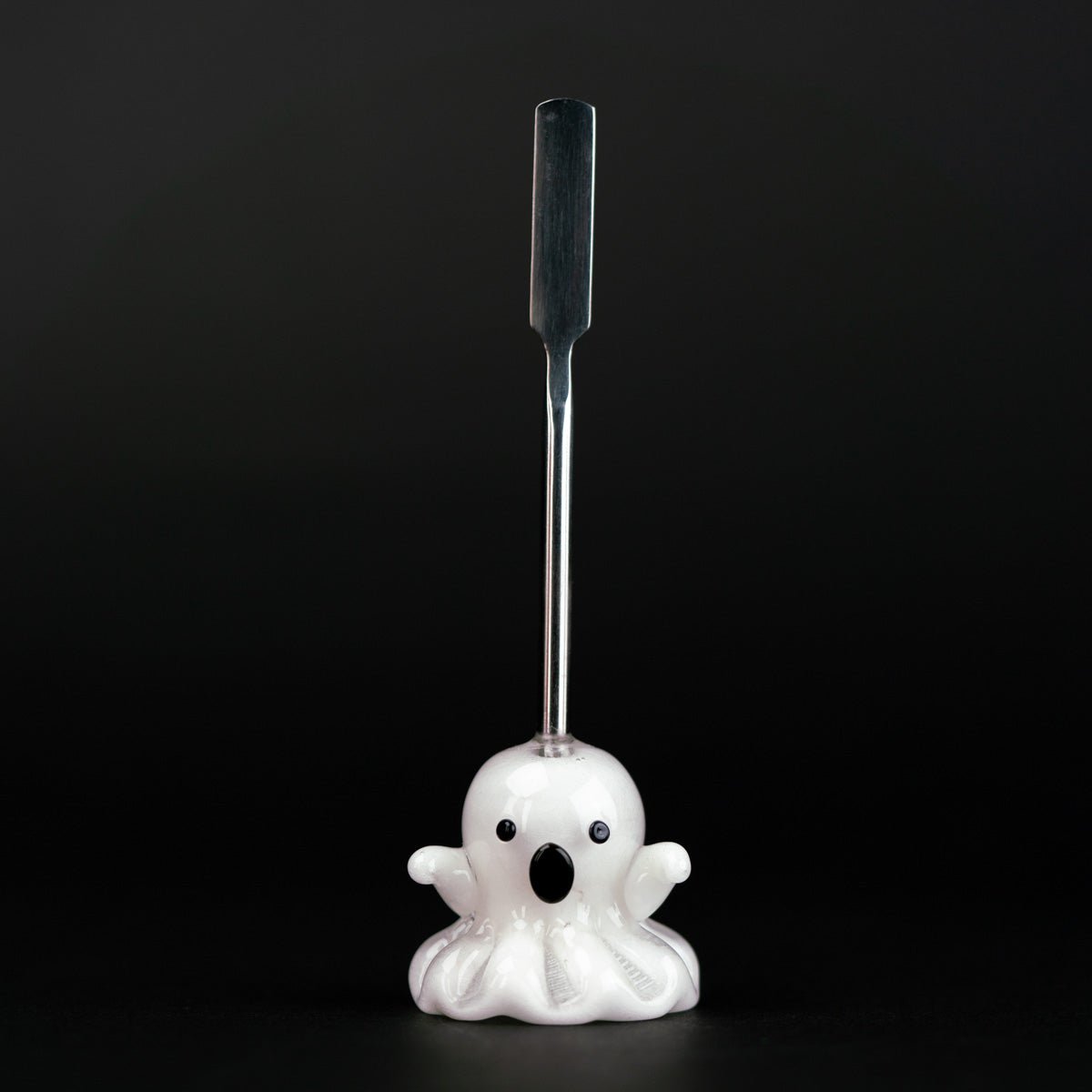 A metal dabber tool with a glass ghost figurine attached