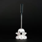 A metal dabber tool with a glass ghost figurine attached