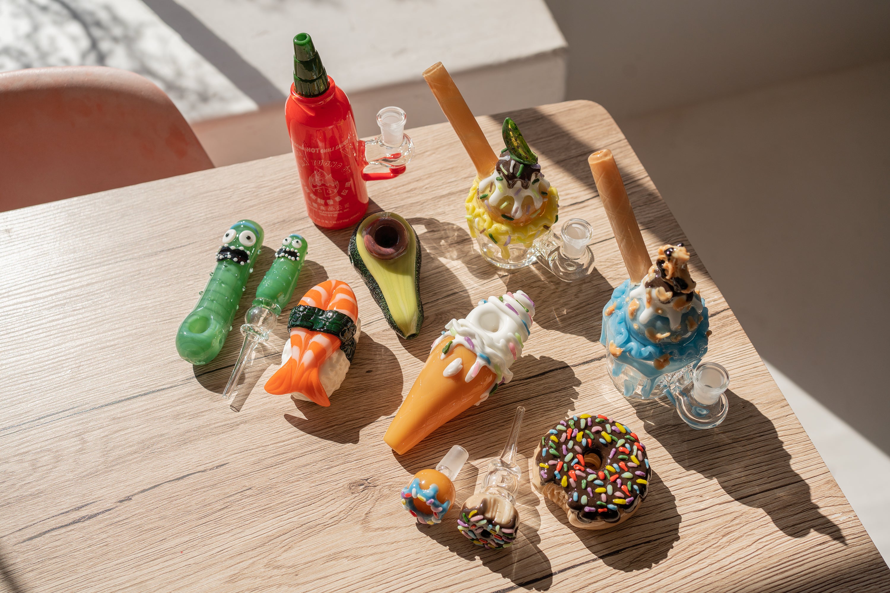 An assortment of different glass products designed by Empire Glassworks including mini rigs, dab rigs, bongs, spoon pipes, bowl pieces, and dry pipes.