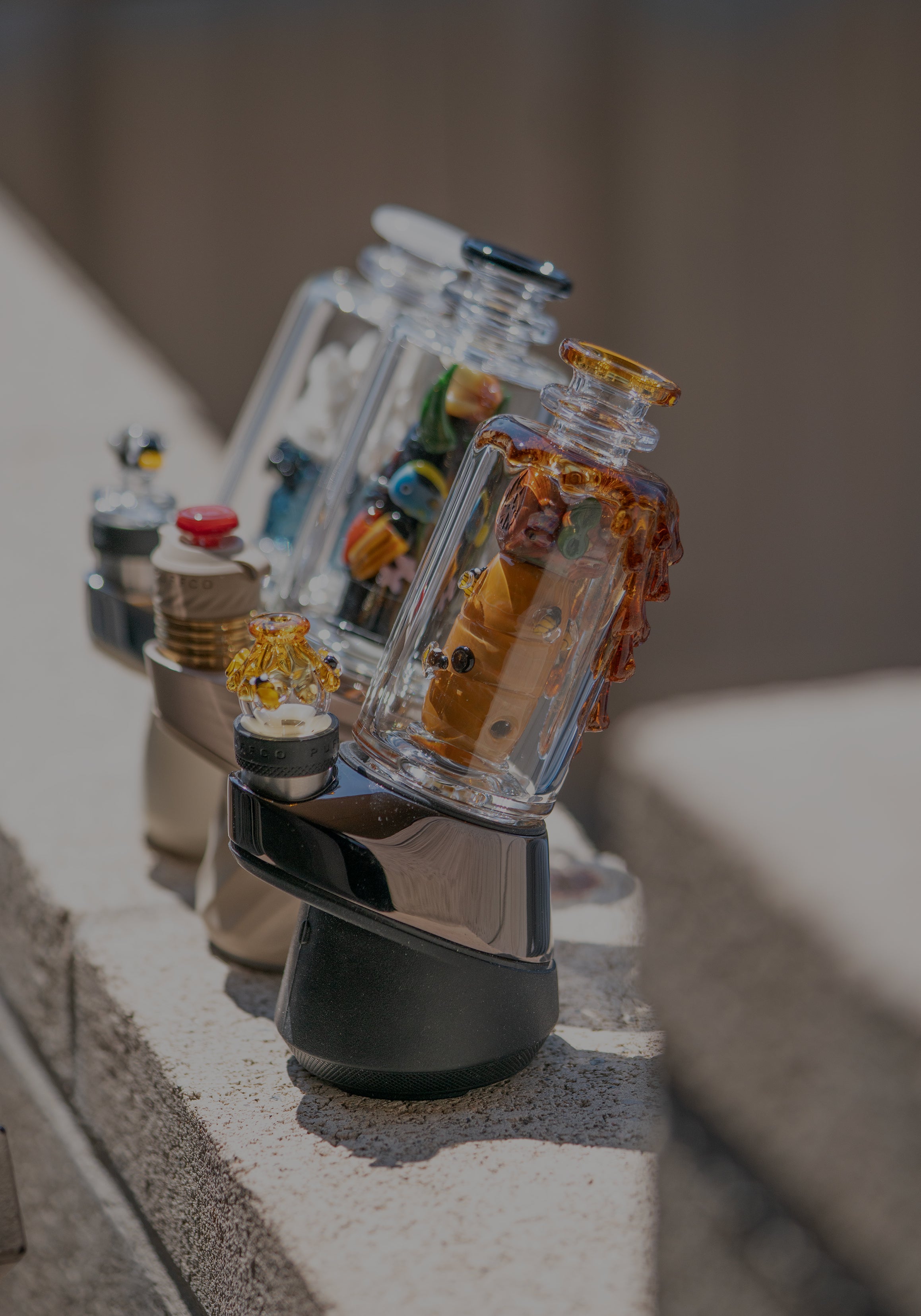 Three Puffco Peak Pro glass attachments designed by Empire Glassworks including the save the bees, under the seas, and avenge the arctic pieces