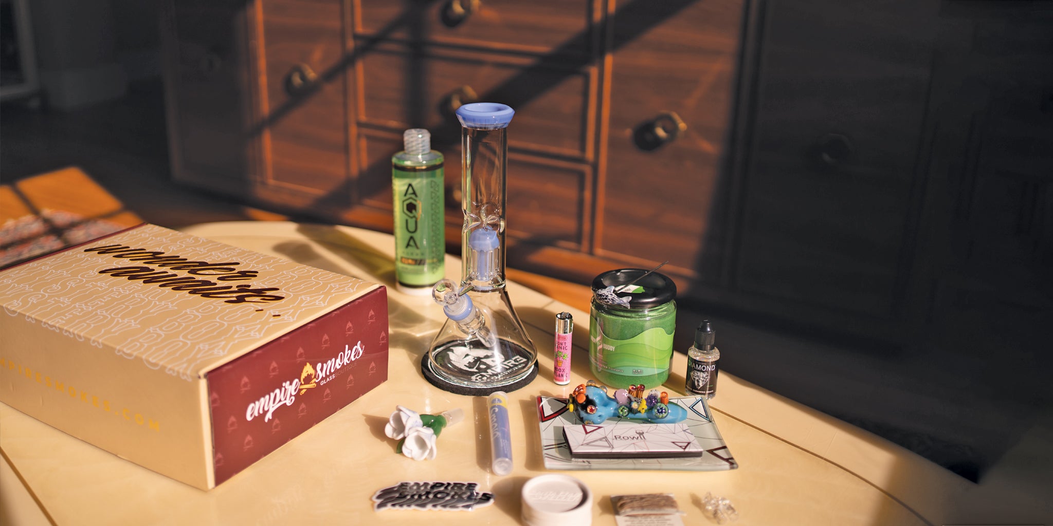 A look at what may be included with the Empire's Smokes mystery box product including a glass bong, lighters, spoon pipes, bowl piece, and cleaning solution