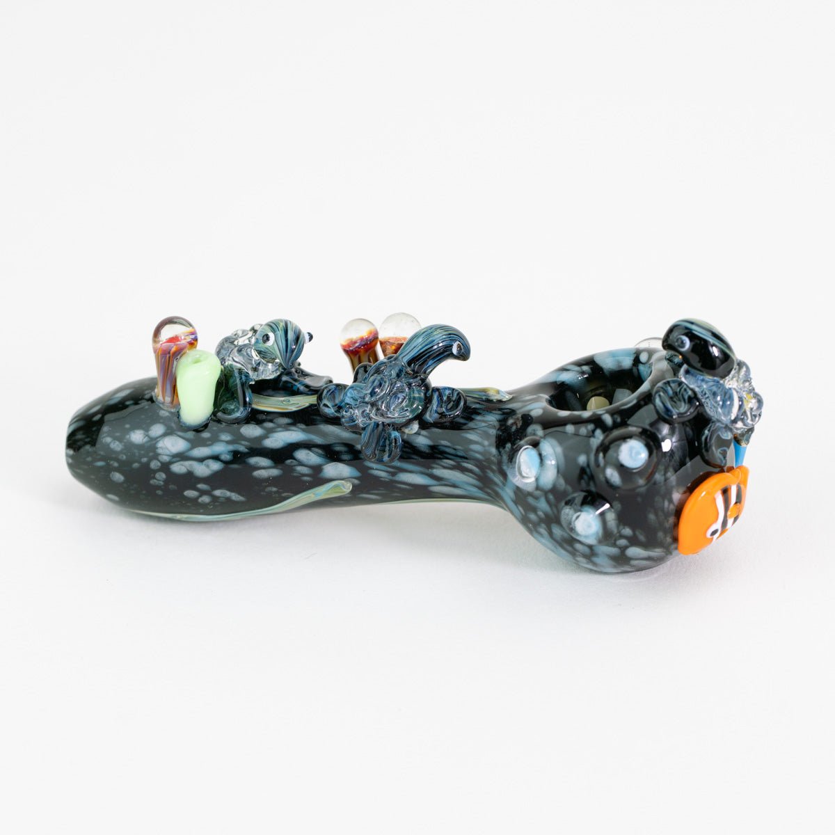 A glass pipe with sea animal figurines on white background