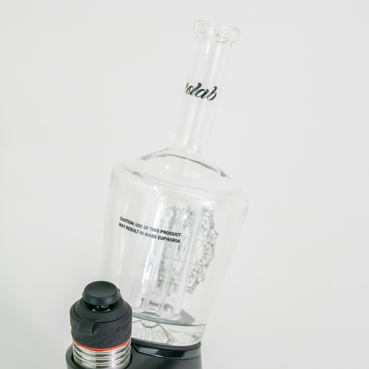 Glass water bottle with a black cap on a white background