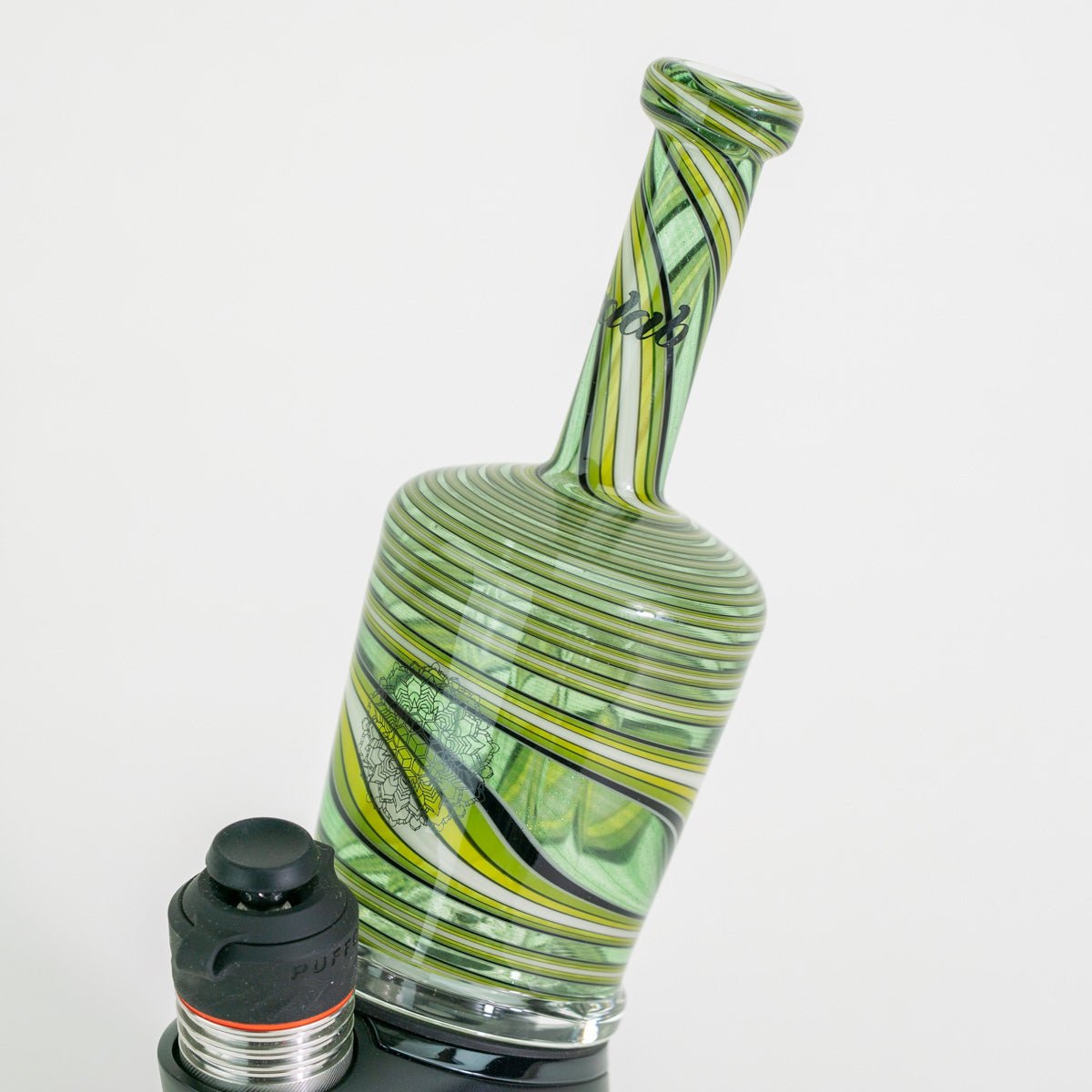 Green and clear glass pipe with a black cap on a white background