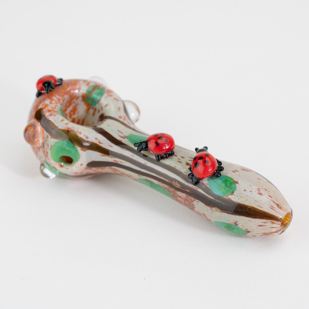 A small decorative spoon pipe with ladybugs on white background