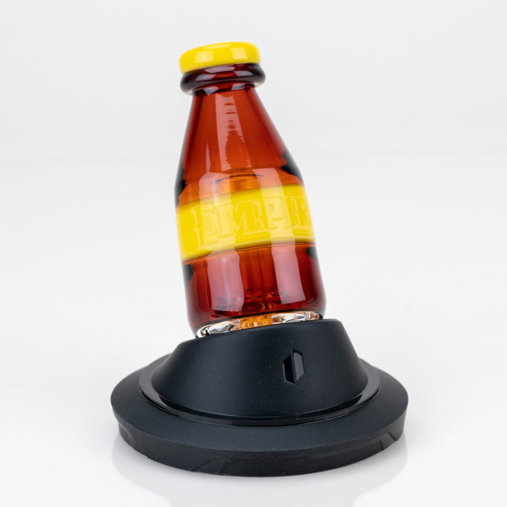 Mexican Pilsner Puffco Peak glass attachment with beer bottle inspired design by Empire Glassworks seated on a Puffco Peak display stand