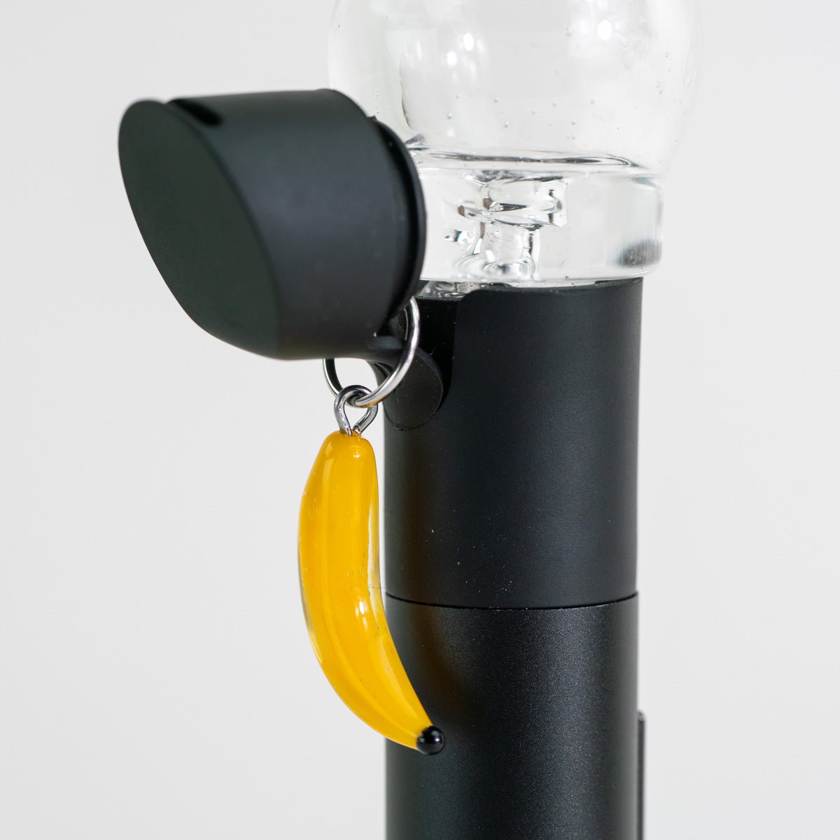 Banana glass Puffco charm with a playful fruit-inspired design attached to a Puffco Pivot