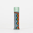 A tall, cylindrical hand-blown glass vase with a light green textured top and a wavy, multicolored striped pattern in gray, blue, orange, red, and green on a white background.