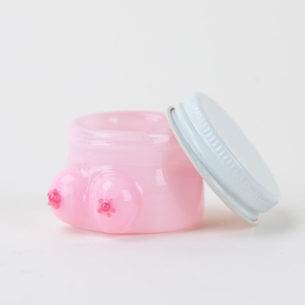 Pink glass terp jar with playful Boobies design and covered concentrate storage