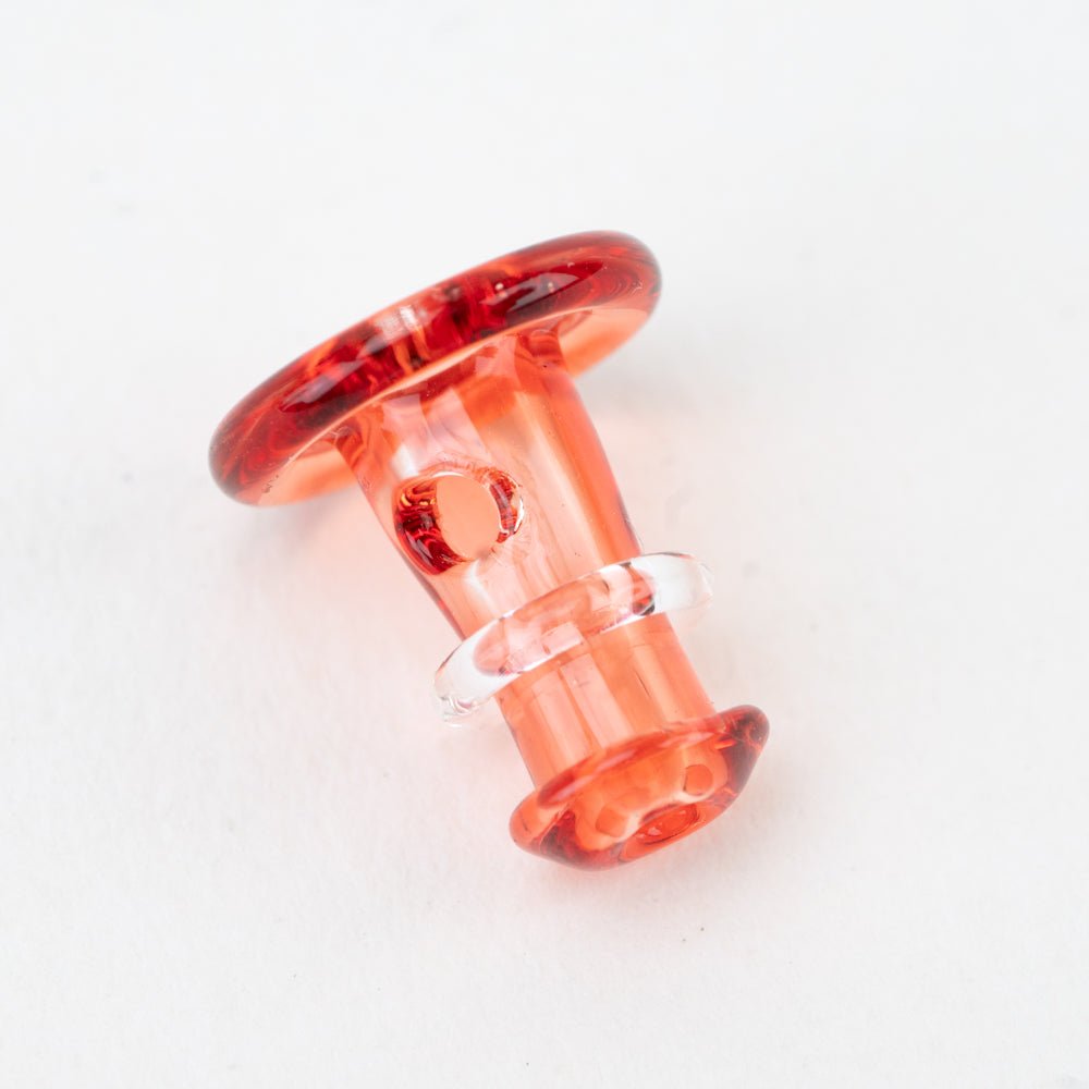 Close-up of a red Puffco joystick cap with translucent glass color