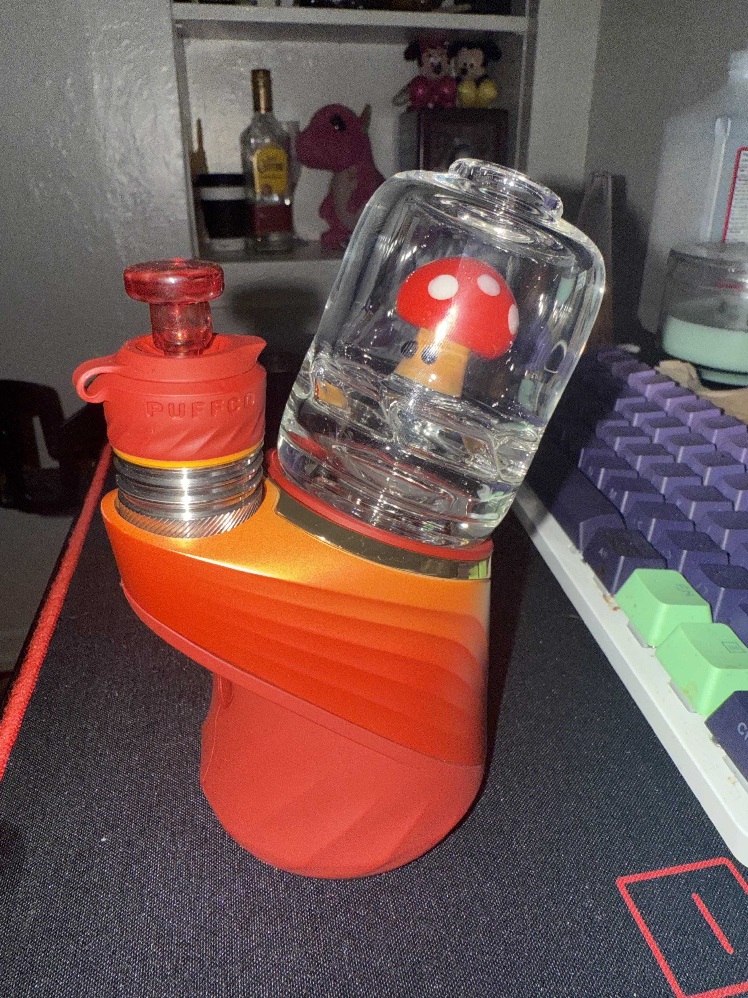 A red mushroom glass attachment on a Puffco peak pro vaporizer