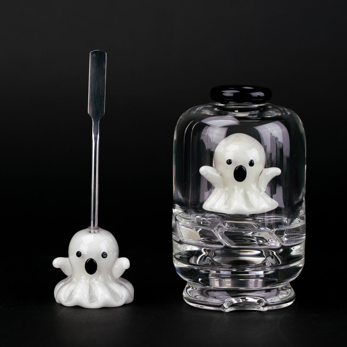 Glass Puffco attachment with a ghost inside, next to a white ghost metal dabber tool