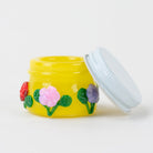 Yellow glass concentrate jar with red, pink, and purple flower artwork