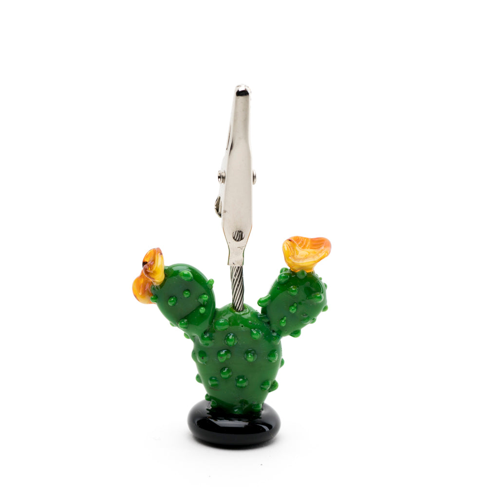 A roach clip shaped like a cactus used for holding joint. The roach clip base is green and has flowering blooms on either side.